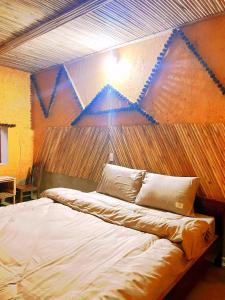ein Schlafzimmer mit einem großen Bett mit einer Holzwand in der Unterkunft huy mán bungalow in Ha Giang