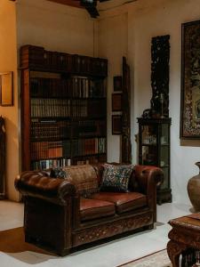 a living room with a leather couch and a book shelf at Mintys Folly 2 in Ban Man