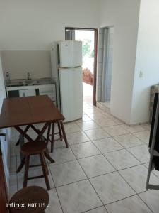 a kitchen with a table and a refrigerator at Pousada Mar e Sol Indaiá in Bertioga +26 photos