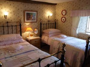 a bedroom with two beds and a window at High Wray Farm in Ambleside