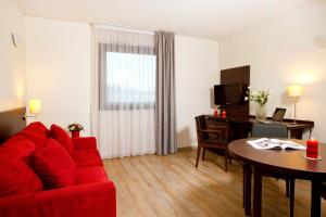 a living room with a red couch and a table at Residhome Toulouse Tolosa in Toulouse