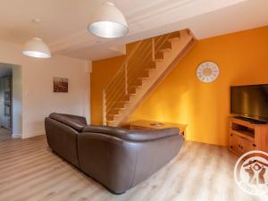 a living room with a couch and a staircase at Gîte Camomille à la campagne, proche du Puy du Fou - FR-1-622-99 in Saint-Georges-du-Puy-de-la-Garde
