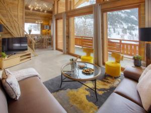 a living room with a couch and a table at Chalet luxe 5★, 6 pers, hammam, près des pistes, 3 chambres - FR-1-304-305 in La Clusaz
