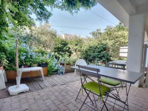 un patio avec une table, des chaises et des fleurs dans l'établissement Appartement pour 4 pers avec WIFI, proche marché - FR-1-475-197, à Saintes-Maries-de-la-Mer