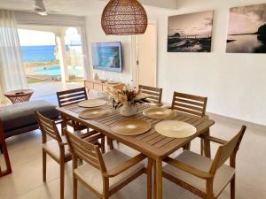 弗利康弗拉克Solara West - Private Pool and Seafront的配有木桌椅的餐厅