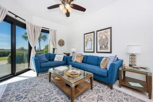 a living room with blue couches and a table at Phoenix VII 7015 condo in Orange Beach