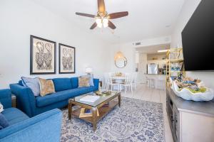 a living room with a blue couch and a table at Phoenix VII 7015 condo in Orange Beach