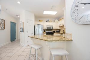 a kitchen with a large clock on the wall at Phoenix VII 7015 condo in Orange Beach