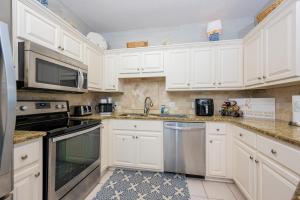 a kitchen with white cabinets and stainless steel appliances at Phoenix VII 7015 condo in Orange Beach