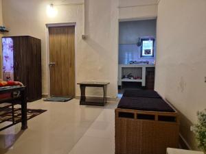グワーハーティーにあるGriho Kuwoli - 'A1RK personal home' with private kitchenの広いリビングルーム(テーブル、ドア付)