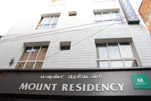 a white building with a sign in front of it at Mount Residency in Chennai