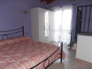a bedroom with a bed and a window at La Rosa dell'Etna in Castiglione di Sicilia