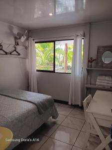 a bedroom with a bed and a table and a window at Doris&Ted House in Golfito