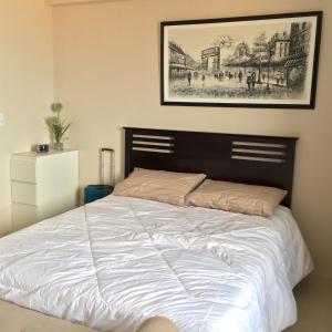 - une chambre dotée d'un lit avec une photo sur le mur dans l'établissement One Palm Tree Villa CC9N, à Manille
