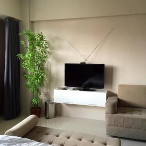 - un salon avec une télévision et un canapé dans l'établissement One Palm Tree Villa CC9N, à Manille