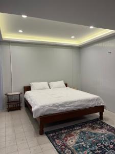 a bedroom with a large bed with a rug at Baan Saen Saran residence in Sathani Bang Ramat