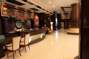 un ristorante con bar e alcuni tavoli e sedie di Ruean Phae Royal Park Hotel a Phitsanulok