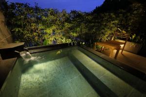 a swimming pool with a bench and a table at Kinzan in Kobe