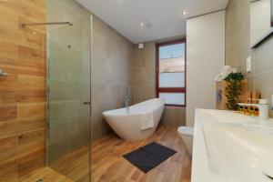 a bathroom with a tub and a glass shower at Exclusive townhouse Maciejki with garden and terrace near Warsaw in Nowa Wola +59 photos
