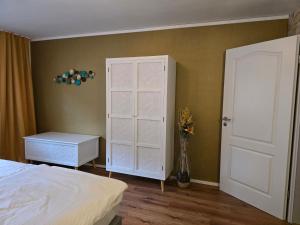 a bedroom with a bed and a white cabinet at Marburg Apartment feuriger Felix mit Kamin und Garten in ruhiger Waldrandlage in Marburg an der Lahn