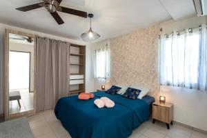 a bedroom with a blue bed with two pillows at TI KAZ BONER Vue Mer in Saint-Pierre