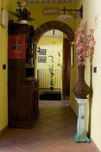 Un pasillo con un arco y un jarrón con flores. en Arco Dei Nobili, en Monforte dʼAlba
