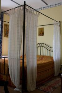 a bedroom with a canopy bed with white curtains at Arco Dei Nobili in Monforte dʼAlba
