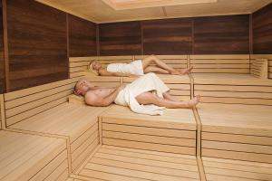 
a man laying on top of a wooden floor at Spa & Wellness Hotel Pinia in Malinska

