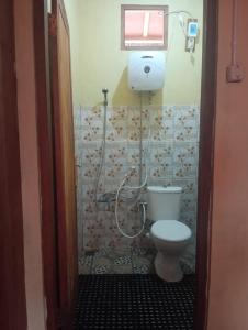 a small bathroom with a toilet and a window at Watuburu Cottage & Restaurant in Kelimutu