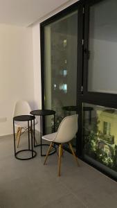 a room with two chairs and a table and a window at Monoambiente La Plata SOHO zona Shopping in La Plata