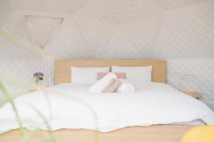 a bedroom with a white bed with towels on it at zhus garden in Kilsyth +41 photos