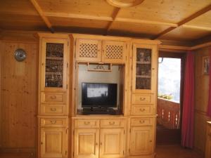 a living room with a tv and wooden cabinets at Holiday apartment near ski area in Aschau