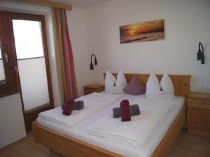 a bedroom with a large white bed with red pillows at Holiday apartment near ski area in Aschau