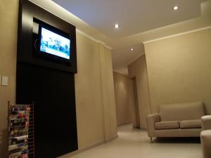 a living room with a television on a wall at Hotel El Cabildo in Buenos Aires