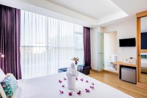 una habitación de hotel con una cama con flores. en Solo Express Sukhumvit 81 en Bangkok