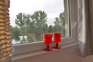 dos velas rojas sentadas en el alféizar de la ventana en Maisonette-Wohnung mit großer Terrasse - 11a, en Maximiliansau 6 fotos más