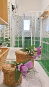 un bagno con due cesti e fiori su un bancone di Casa Tua a Monti a Roma