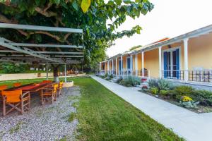 a patio with tables and chairs next to a building at Billy's House in Vasiliki