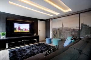 a living room with a couch and a flat screen tv at Pousada Gaúcha in Bombinhas