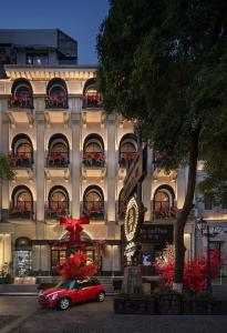 een rode auto geparkeerd voor een gebouw bij 龄舍1927酒店 in Wuhan