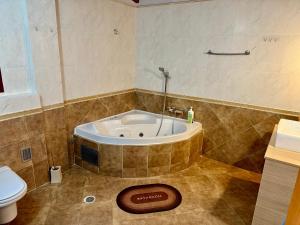 a bath tub in a bathroom with a toilet at Villa Kalli - Porto Ennia in Kalopigado +59 photos