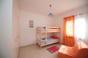 a small room with a bunk bed and a couch at Dream Vacation Apartment in Acharavi