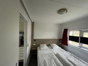 a bedroom with two beds and a window at Hermes Appartementen in Berg en Terblijt