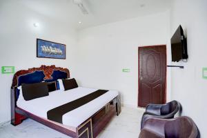 a bedroom with a bed and a tv and a chair at Hotel krishna manu place in Orchha +29 photos
