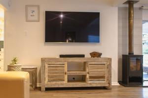 Una sala de estar con un televisor en la pared. en Seeplaas Beach House, en Mossel Bay
