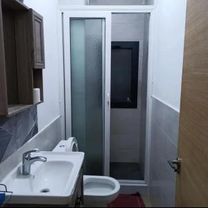a bathroom with a toilet and a sink and a shower at Appartement de luxe à louer in Dakar +4 photos