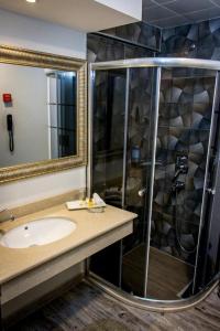 La salle de bains est pourvue d'un lavabo et d'une douche. dans l'établissement Asya Hotel, à Balıkesir