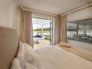 Un dormitorio con una cama y una ventana grande. en Seeplaas Beach House, en Mossel Bay 21 fotos más