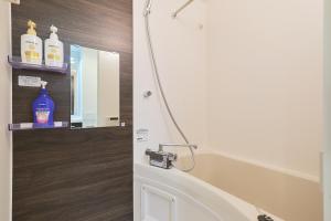 a bathroom with a shower with a mirror and a sink at Ruygo Setagaya by Tranova in Tokyo