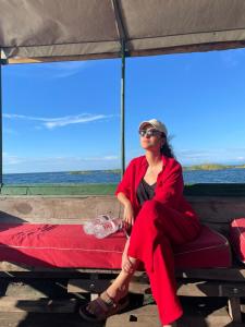 Tongwe Cultural Heritage Center في Katumbi: امرأة تجلس على سرير على الشاطئ